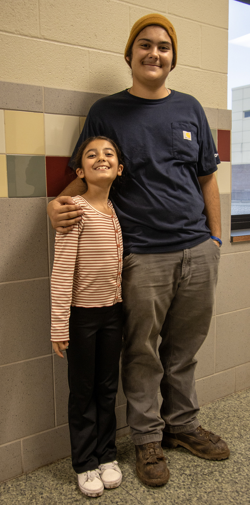 student with younger sister, smiling