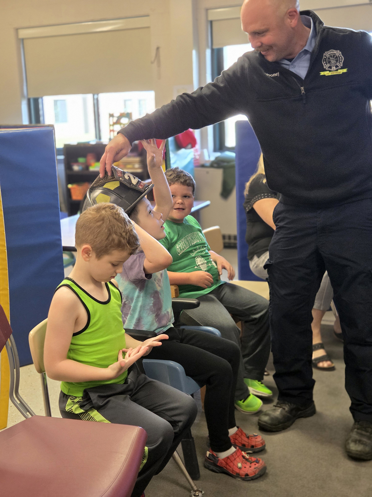 student tries on firefighter's helmet