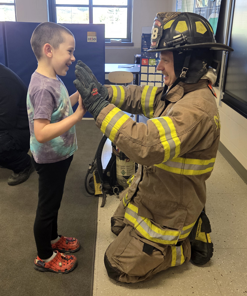 firefighter in turnout gear with a student