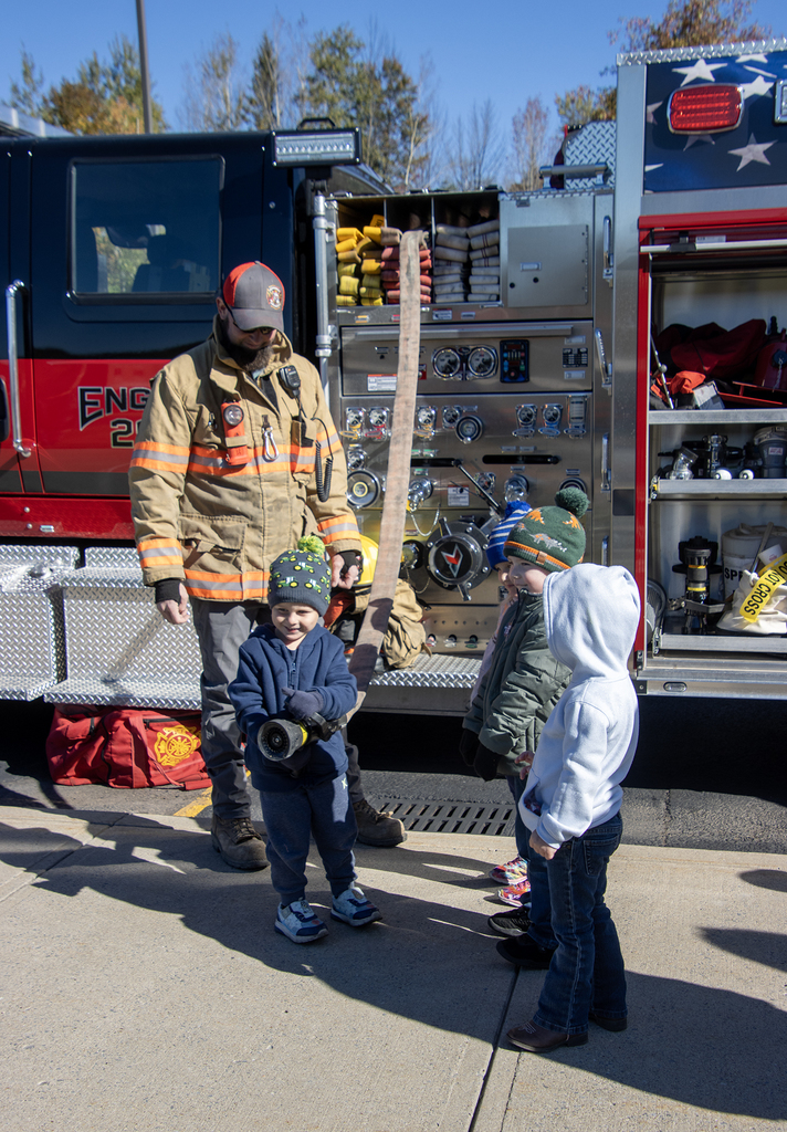 firefighter lets two students hold firehouse