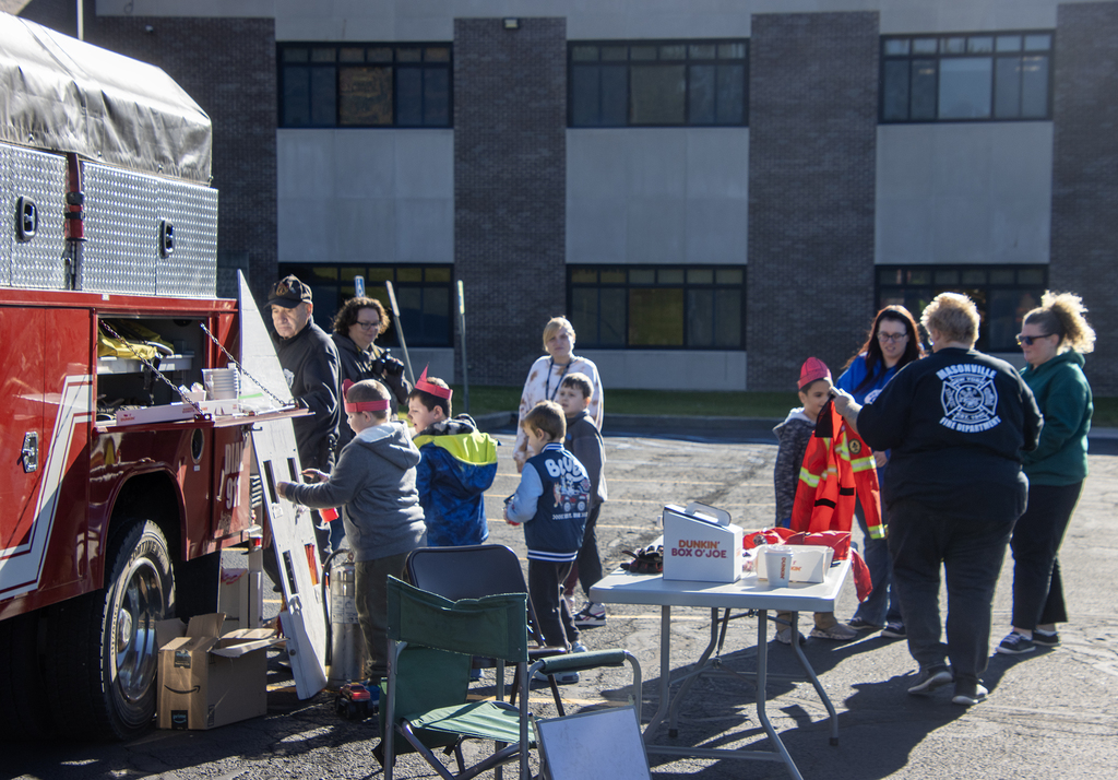 students and firefighters and teachers around the fire truck and activities