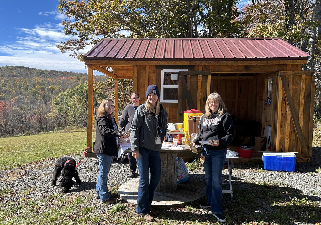 4 adults at a cabin on a hill
