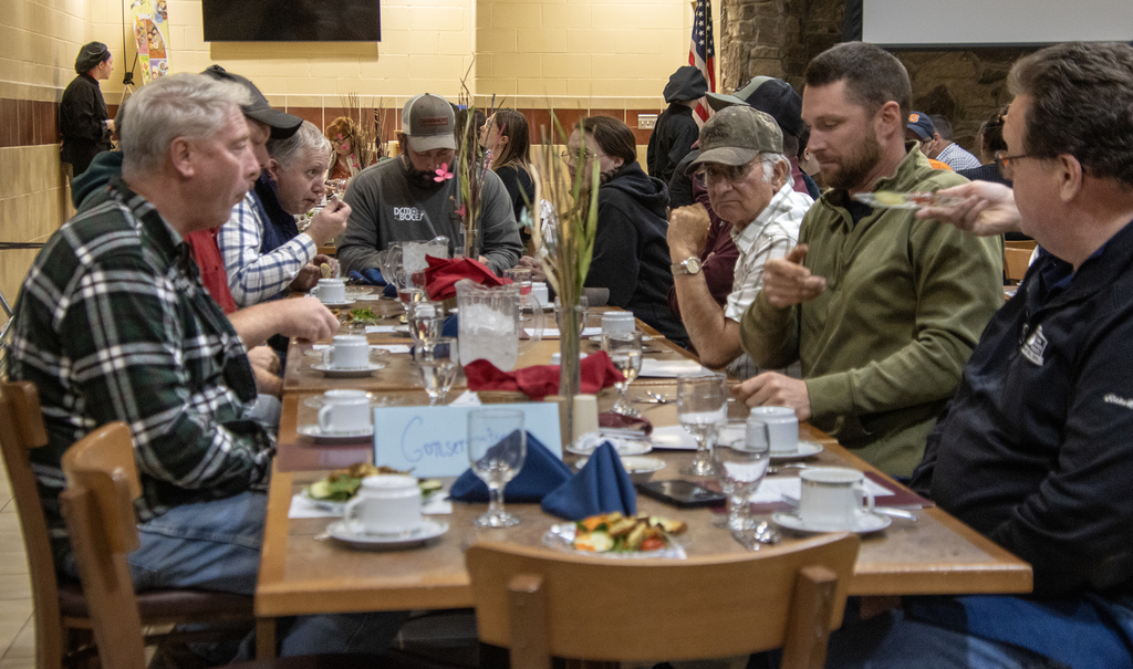 adults eating and talking at table in cafeteria