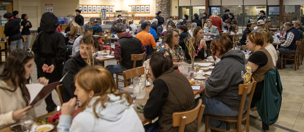 adults eating and talking at table in cafeteria