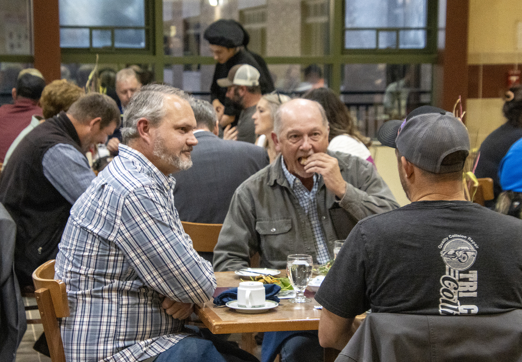 adutlts eating and talking at cafeteria table