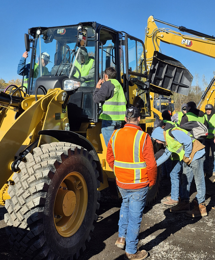 students outdoors with heavy equipment