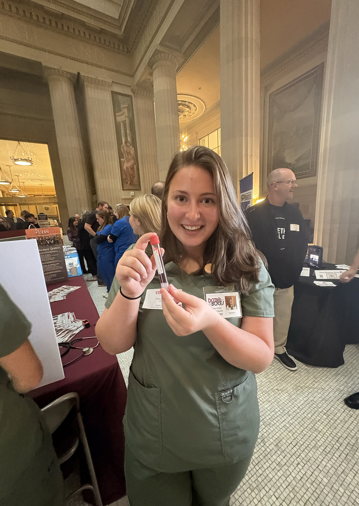 New Visions students holding blood vial