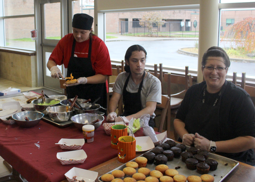 culinary students and teacher at cupcake station
