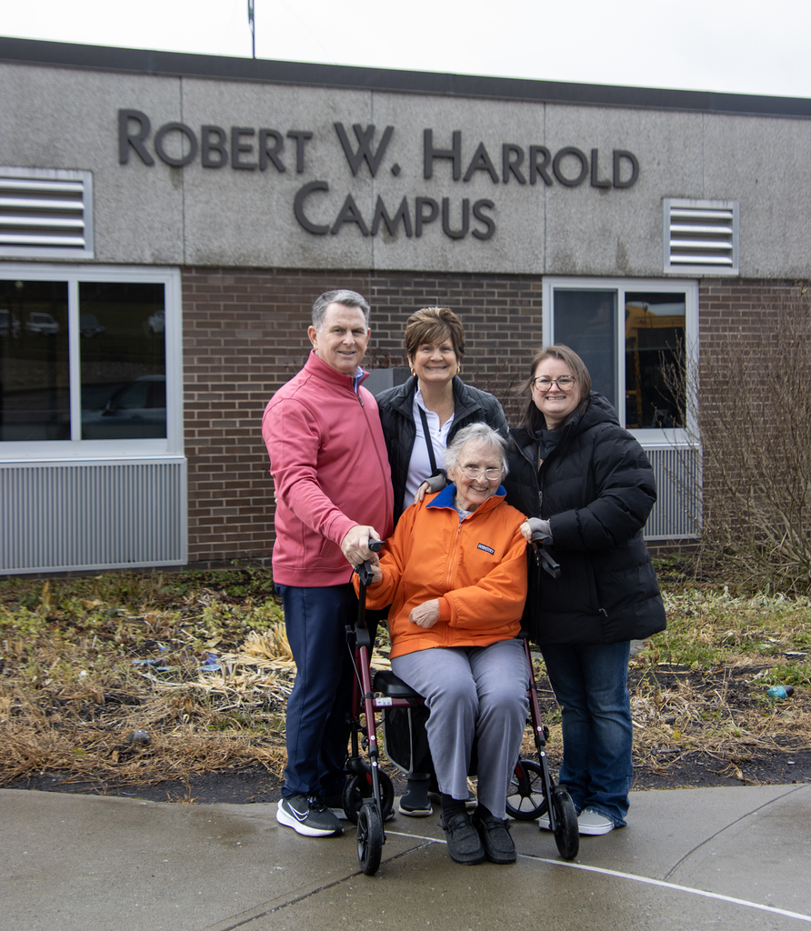 Scott Harrold and his family pose in front of the Robert W. Harrold Campus building sign