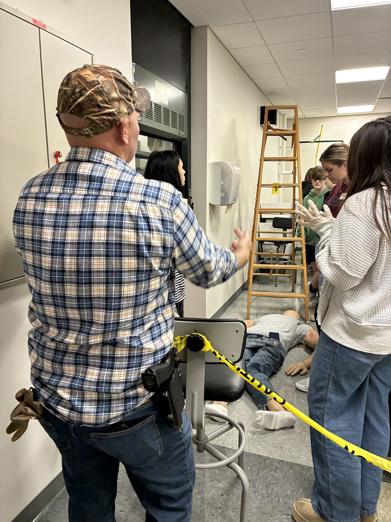 Law enforcement officer guides students through a crime scene