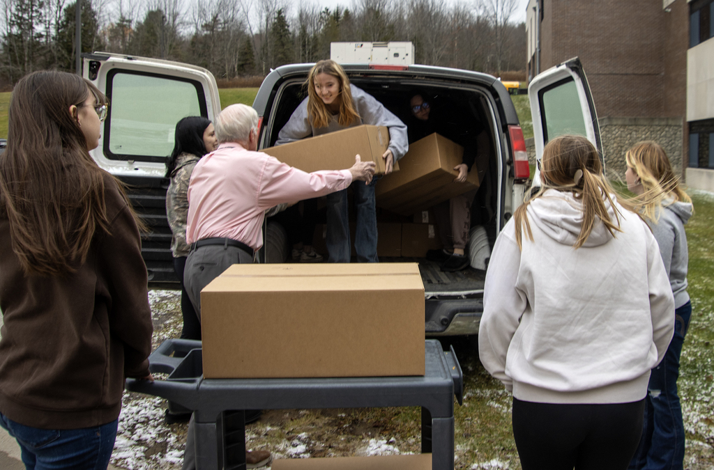 students and teacher unload boxes of bread