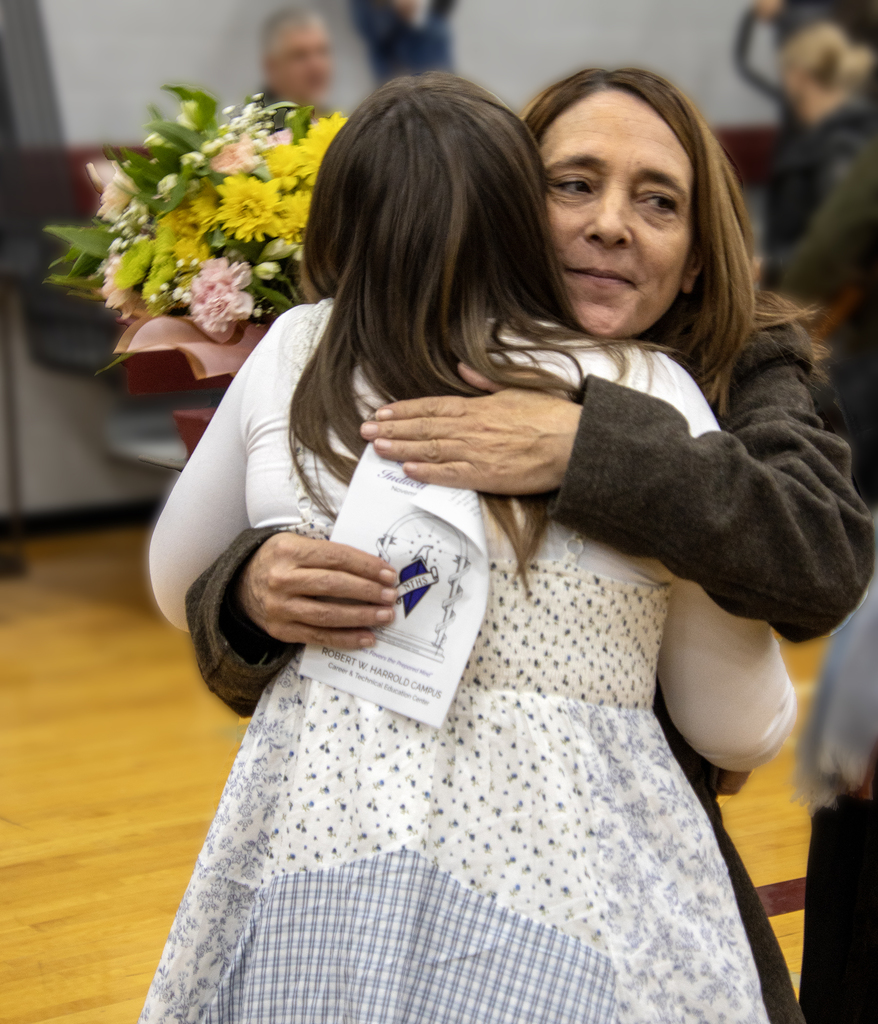mother hugs daughter with flowers