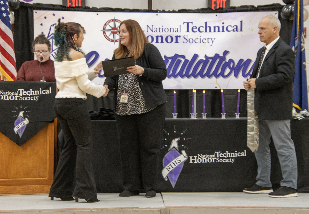 principal congratulations inductee, assistant principal waits with stole
