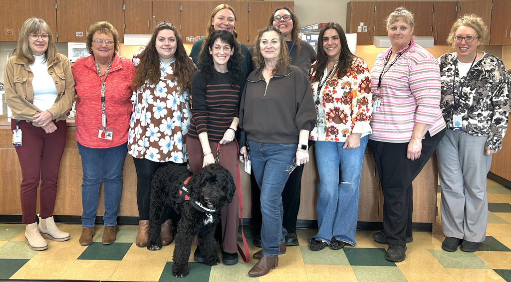 10 staff and a therapy dog pose for a group picture