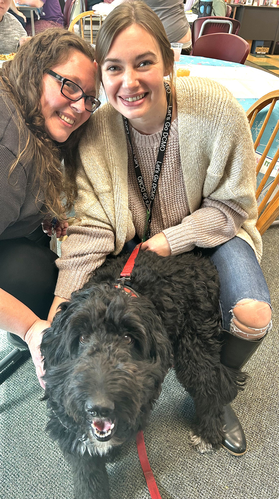 2 staff members with a therapy dog