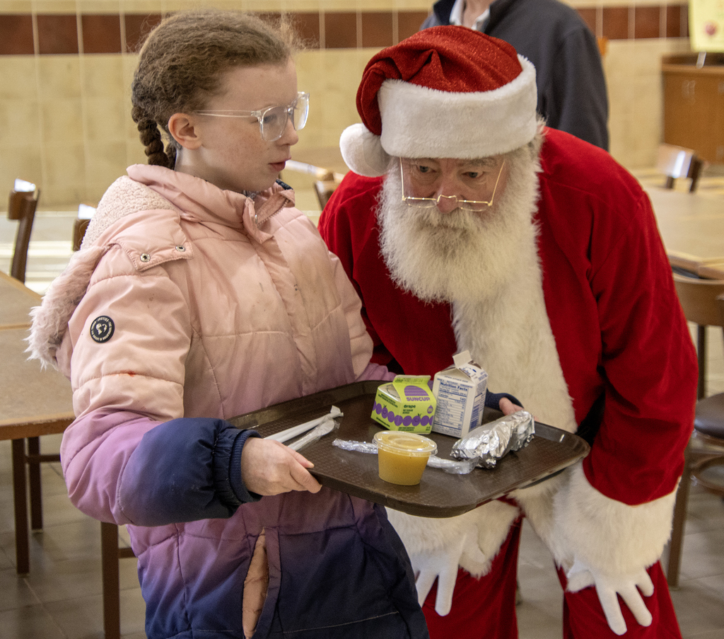 student whispers in Santa's ear