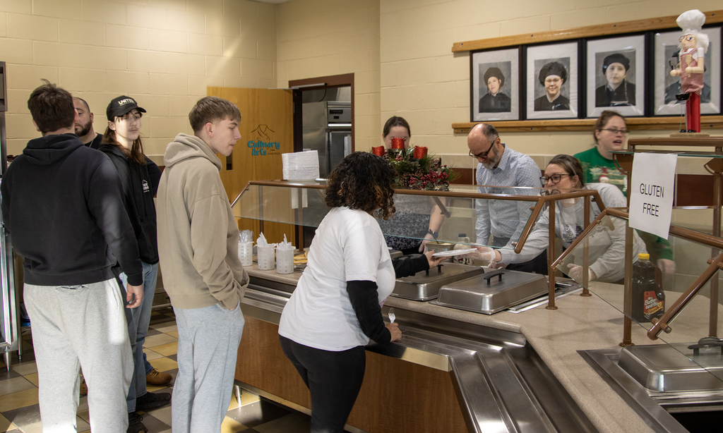 students in line for pancakes served by Support Service Center staff