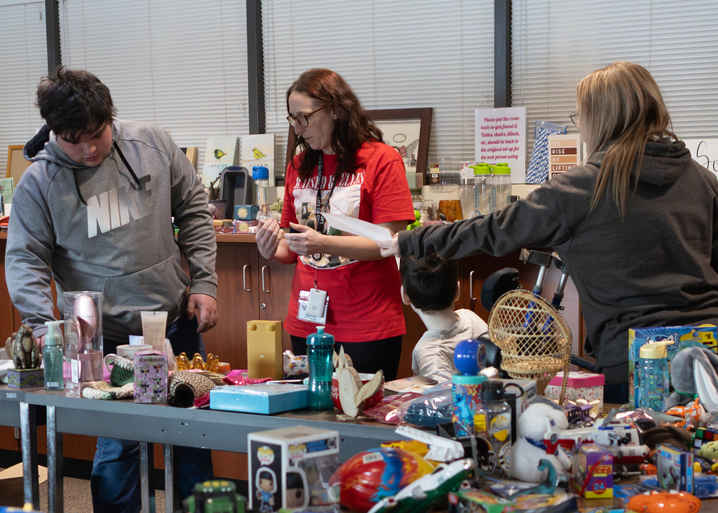 staff and students look at gift options on tables
