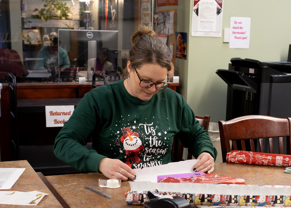 staff person wraps a gift