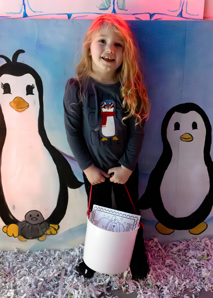 student poses in front of penguins