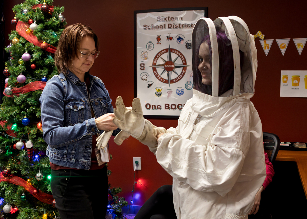 teacher helps with beesuit for student