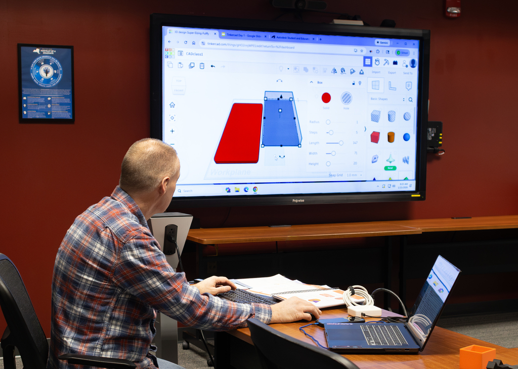 man sharing work from computer on a big screen