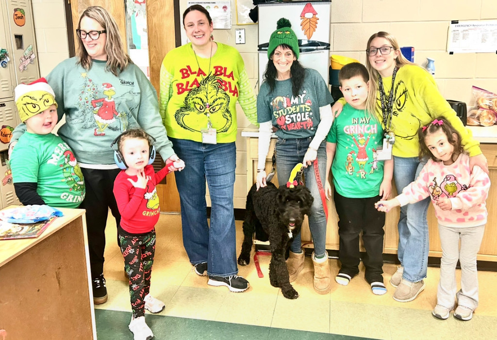 3 teachers and 4 students pose with therapy dog