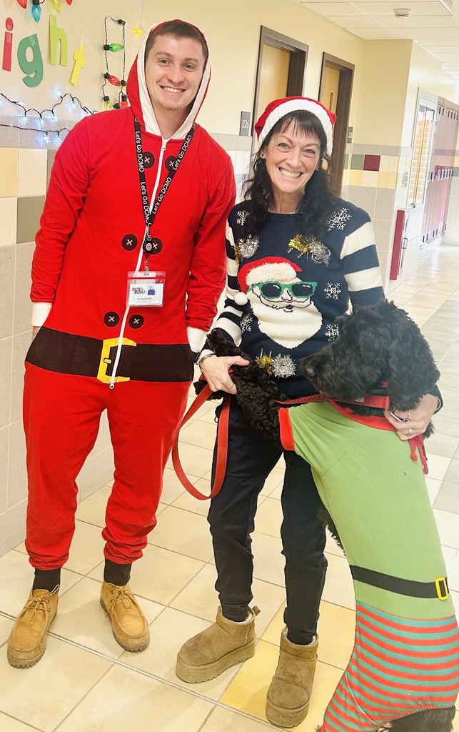 2 adults in Christmas costumes and a dresse up dog