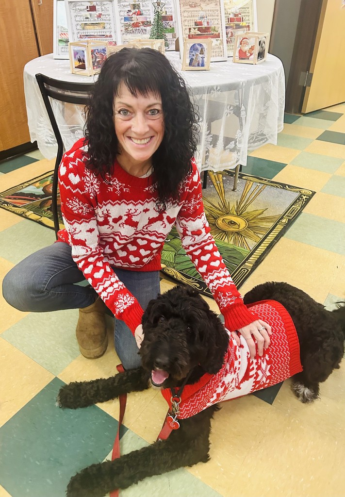 teacher and a dog wearing matching Christmas sweaters
