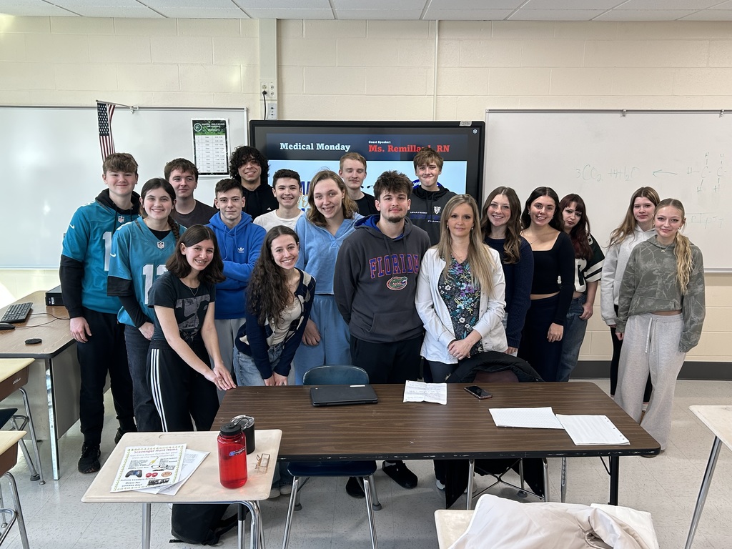 group of smiling students pose with the registered nurse