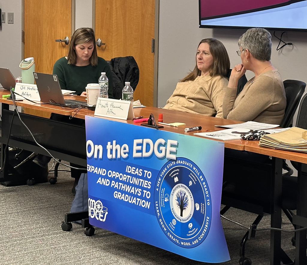 educators in discussion sit at a conference table; banner says "On the Edge - Ideas to expand opportunities and pathways to graduatioin