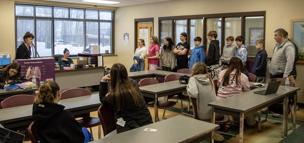 nurse assisting teacher speaks to students