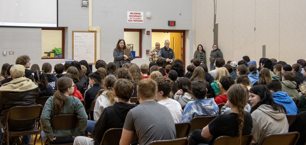 principal speaking to students in gym