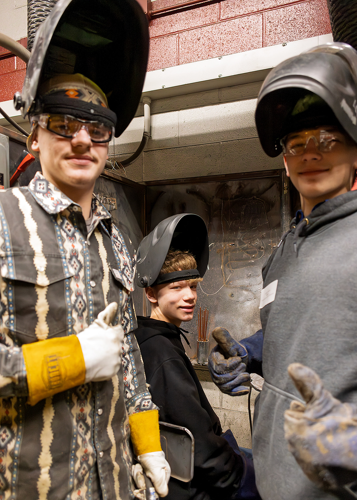 visiting students give the thumbs up in welding lab