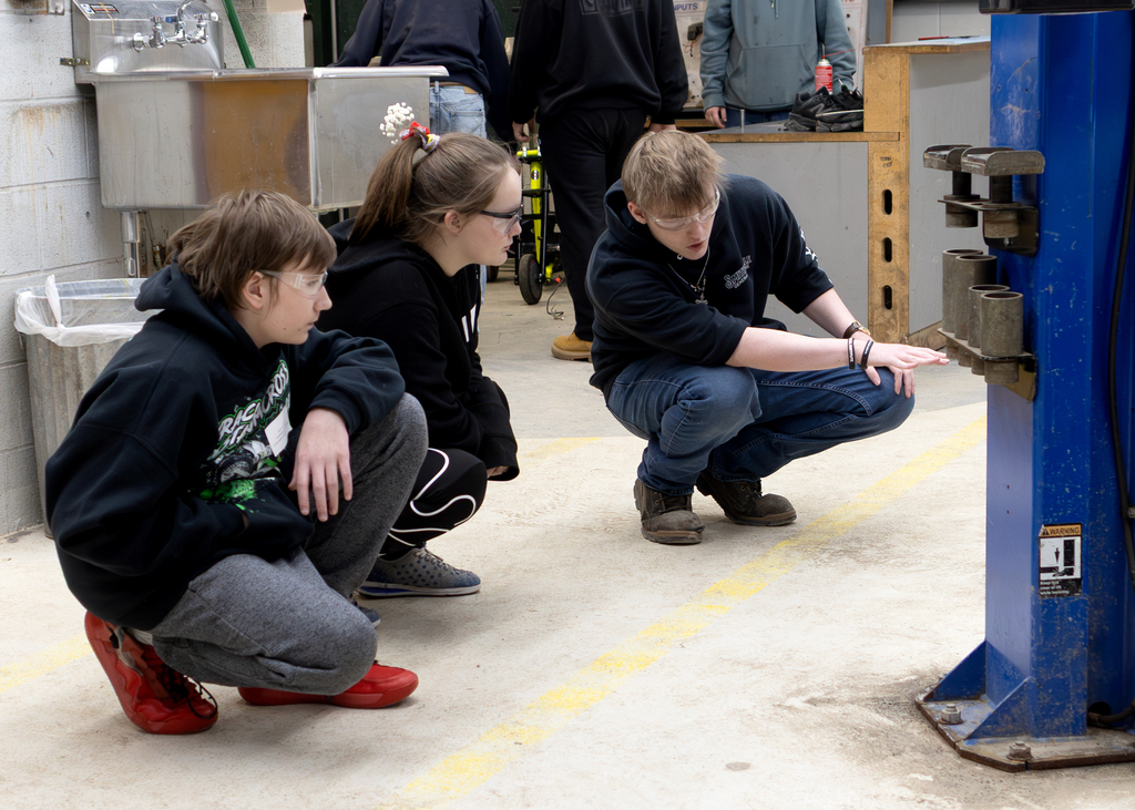 AutoTech student speaking with 2 visiting students