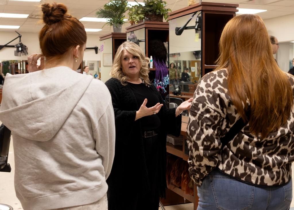 Cosmetology teacher speaks to two students