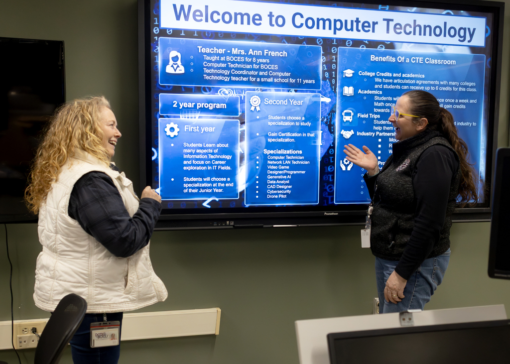 Two adults laughing in computer tech lab