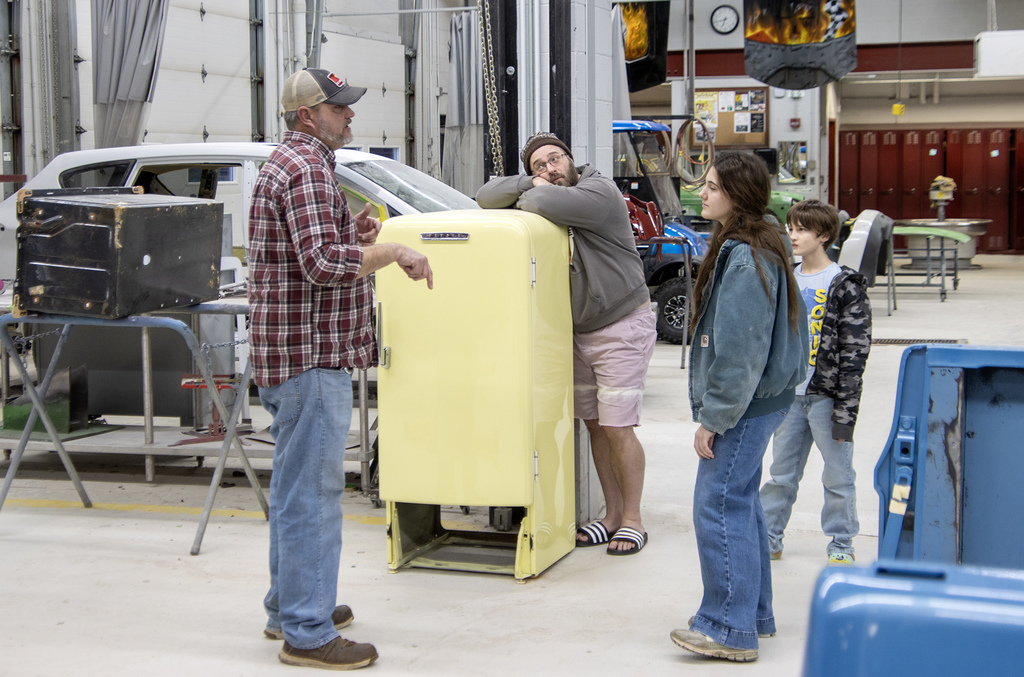 Mr. Harris speaks to student and her family in the auto body shop
