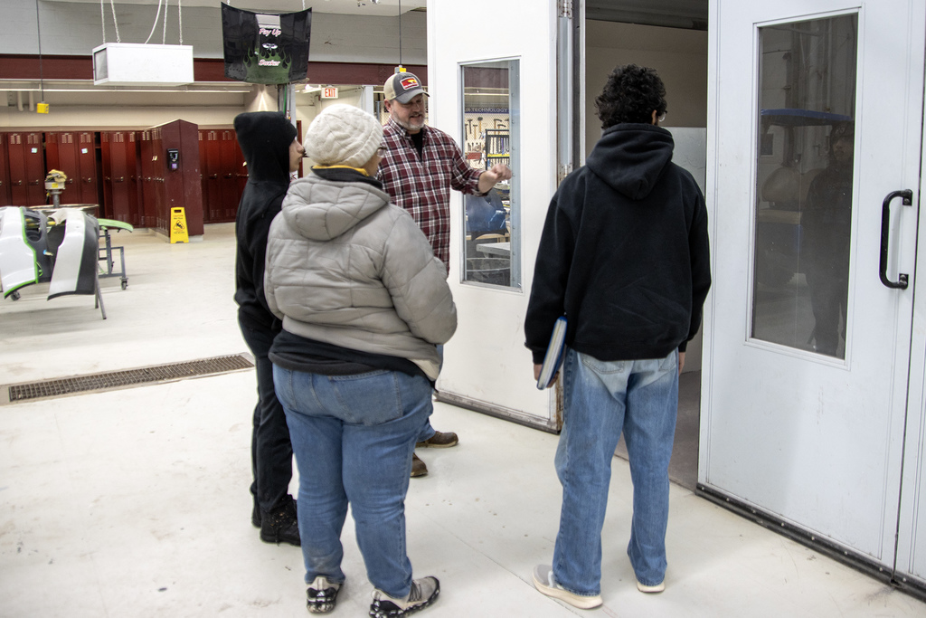 Mr. Harris speaks to students and their family in the auto body shop