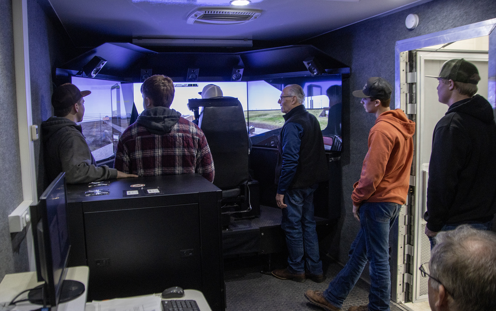 instructor and 5 students inside truck driving simulator 