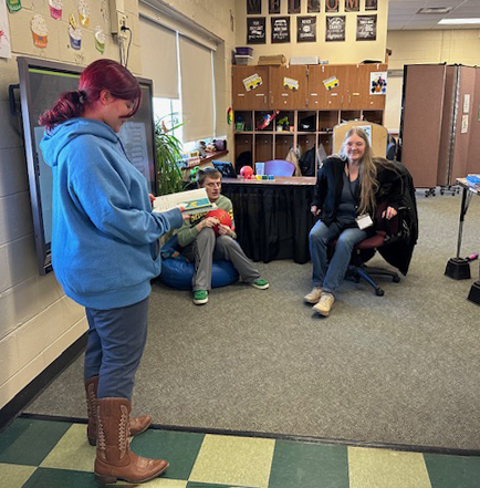 student reading a Dr. Seuss book to others