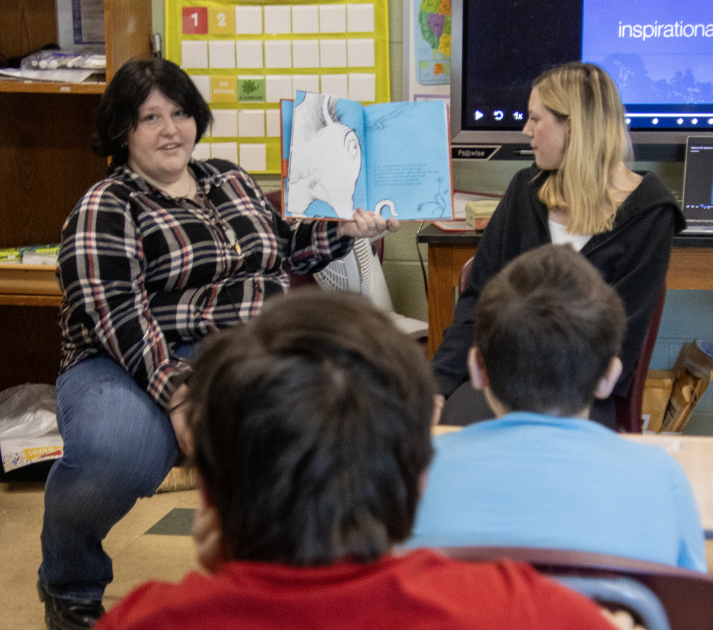 student reading a Dr. Seuss book to others