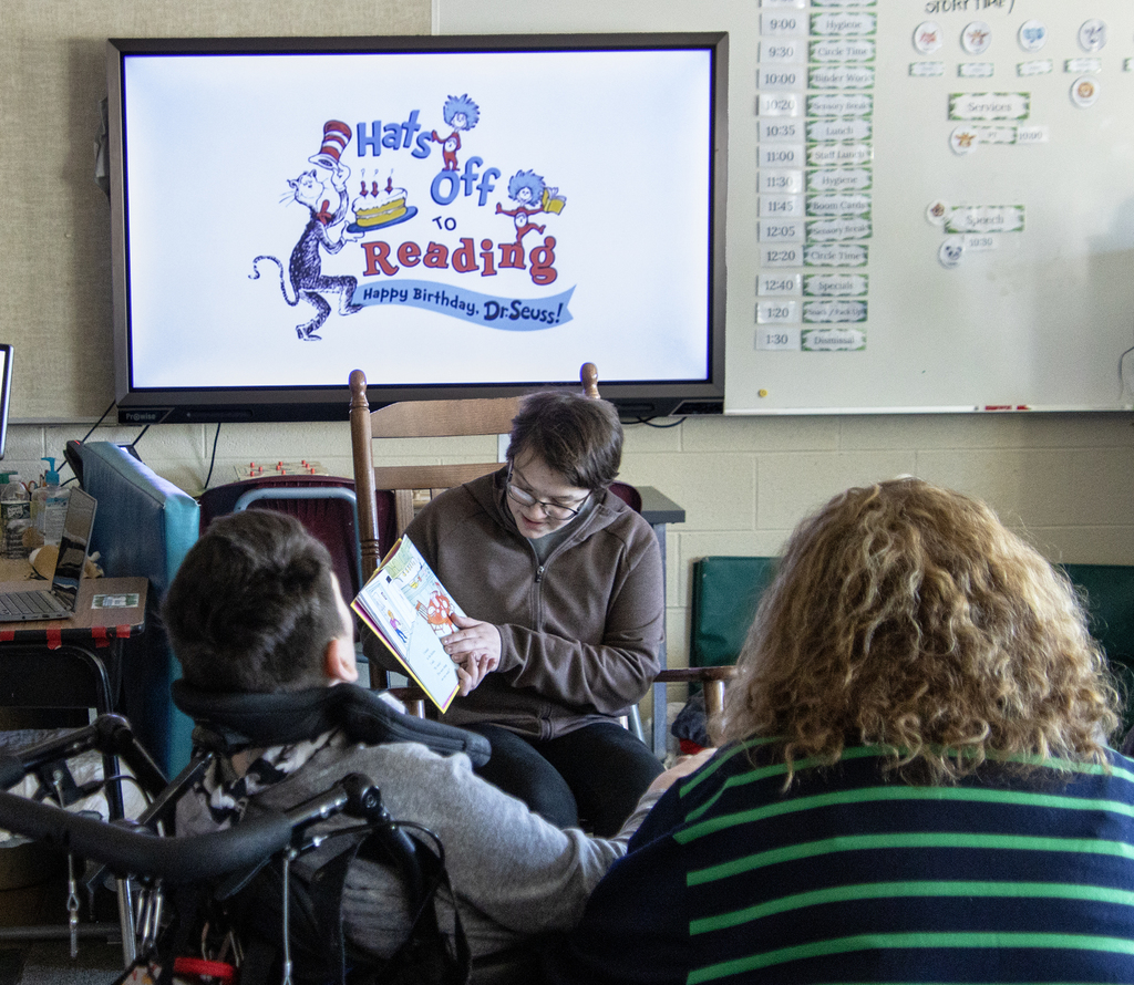 student reading a Dr. Seuss book to others