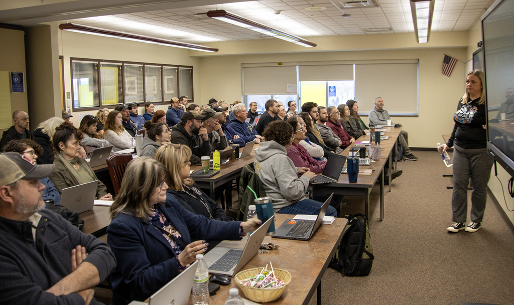 teachers packed into a small meeting room, Jenn Lawrence speaking to them