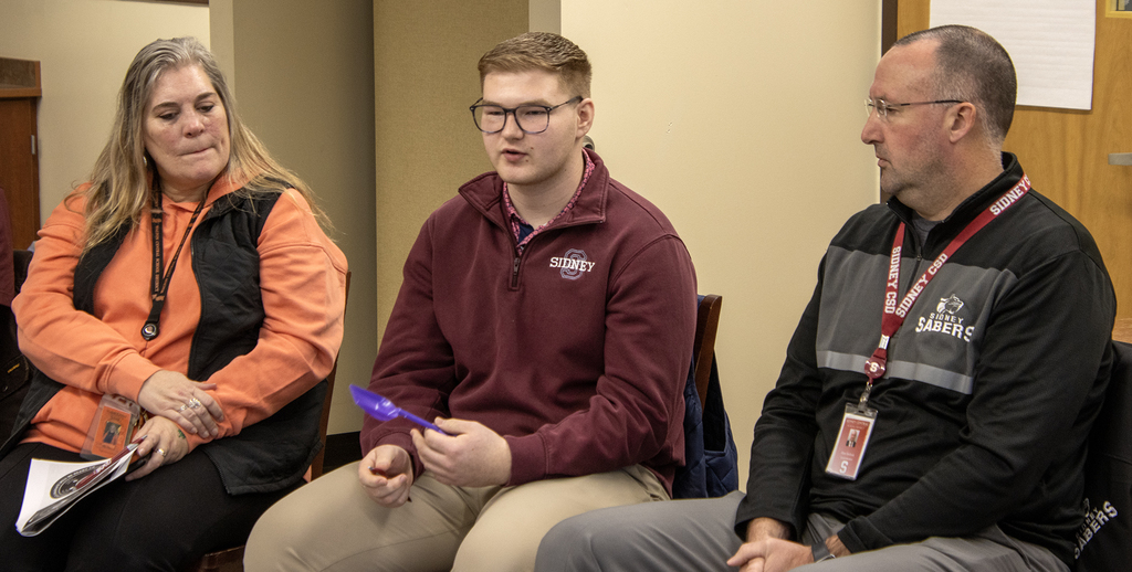 2 administrators and a student in a talking circle