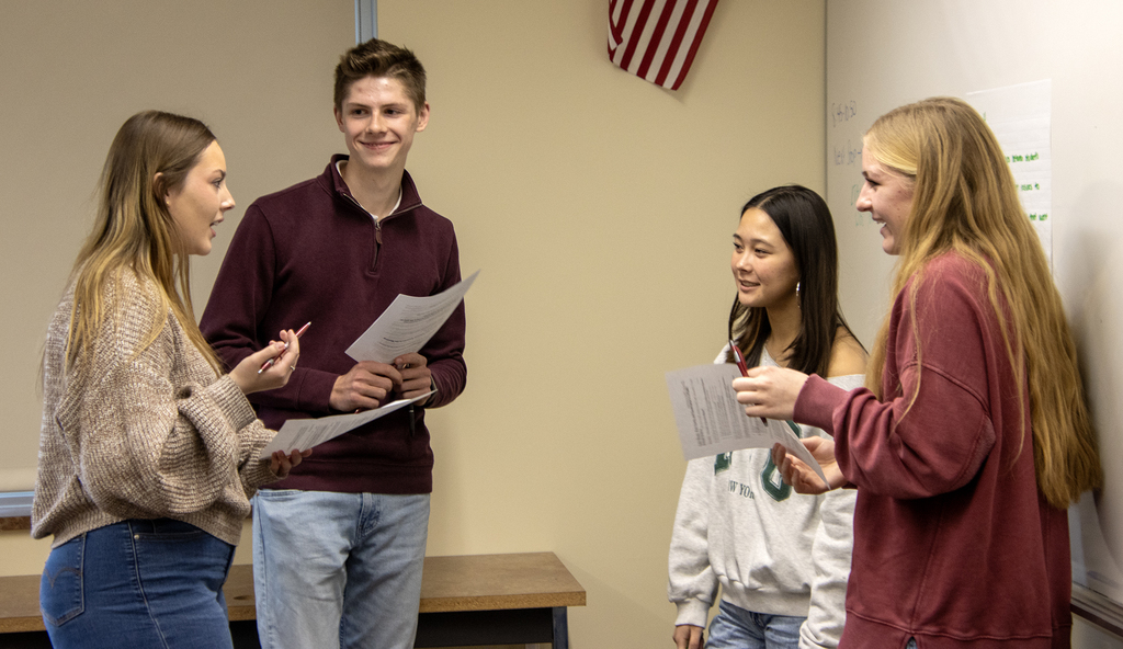 4 students talking, smiling