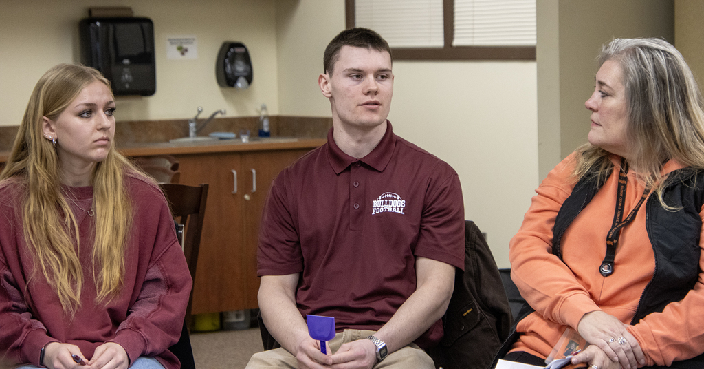 2 students and an adult in a talking circle