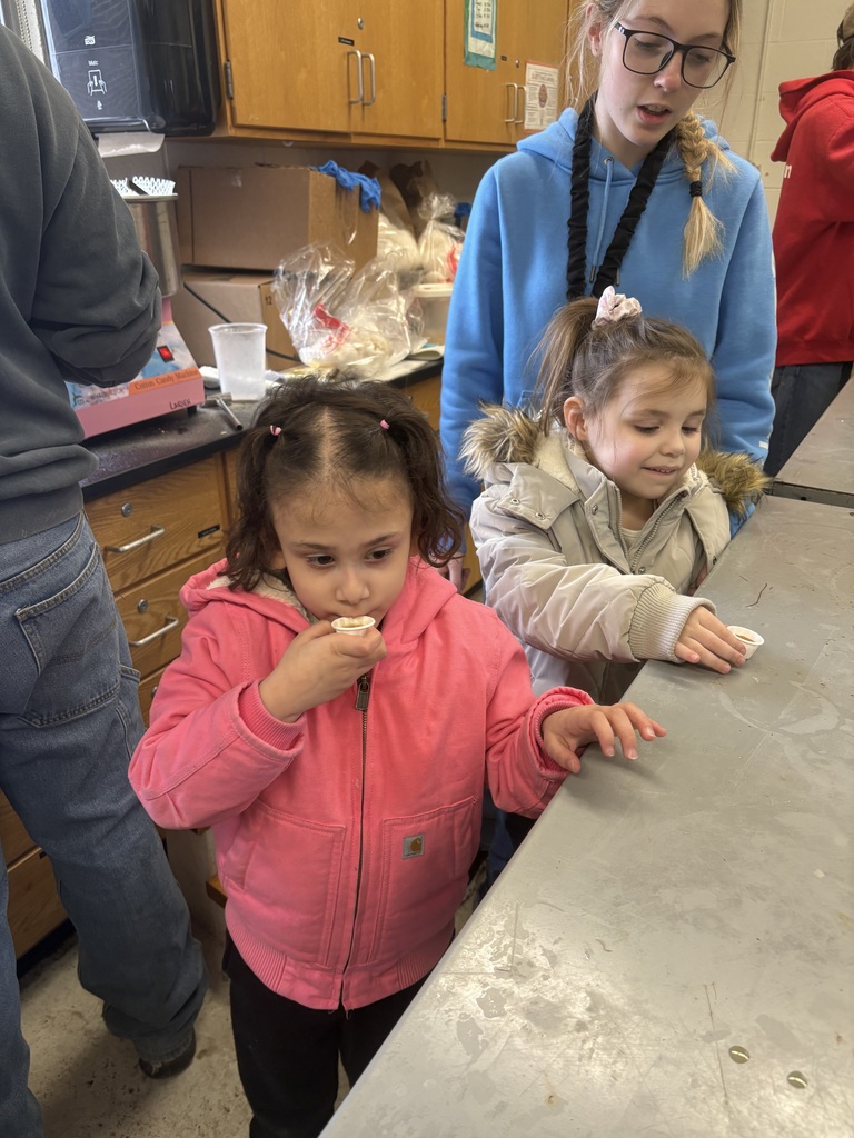 two small children try maple syrup