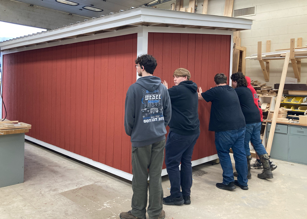 students pushing a building out the door