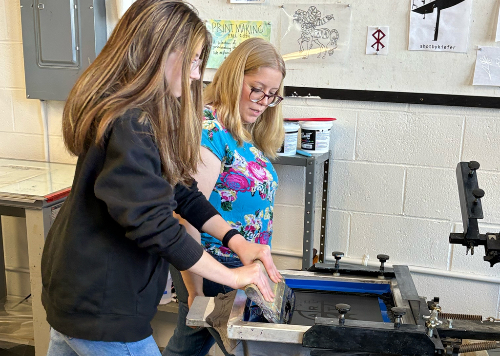 MVCC instructor helping student do screen printing